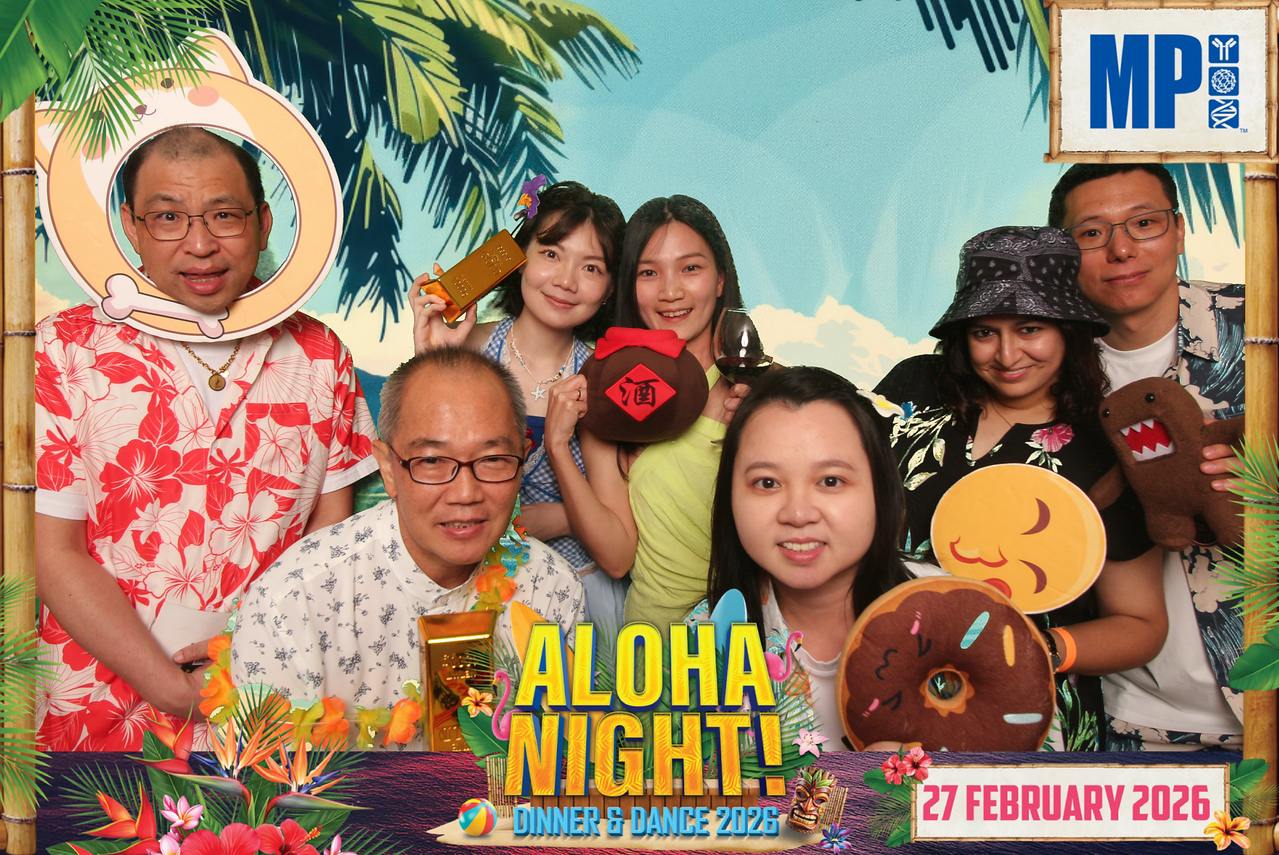 Guests enjoying tropical-themed photo booth props at MP’s Aloha Night in February 2026
